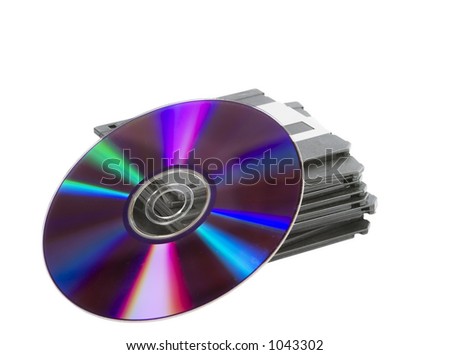 A stack of old dusty 3 1/2" disks and a compact disk, or dvd leaning up against them.