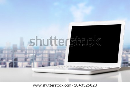 White laptop on white glass talbe