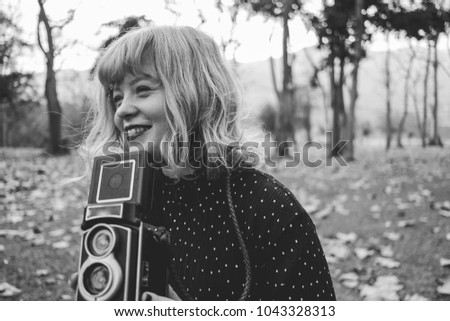 Beautiful young woman with vintage style clothes and camera