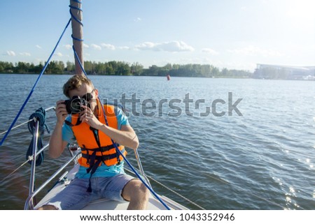 photographer on a yacht. orange life jacket.