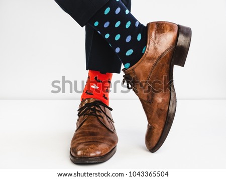 Office Manager in stylish shoes, blue pants and bright, colorful socks on a white background. Lifestyle, fashion, fun
