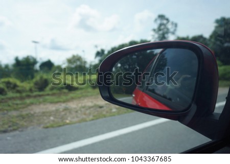 Taking a picture from inside a car. Reflections on a rear view mirror.