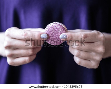 woman holds macaroons in her hands. Close up macro photo of colorful biscuits. Manicure, nail art