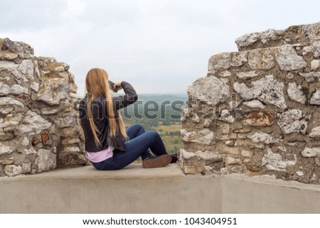excited girl taking a picture on the castle wall