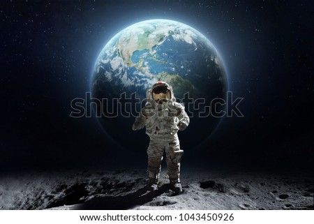 Abstract photo art with astronaut on the Moon surface against Earth on the background, Exploring space and other planets. Elements of this image furnished by NASA Royalty-Free Stock Photo #1043450926