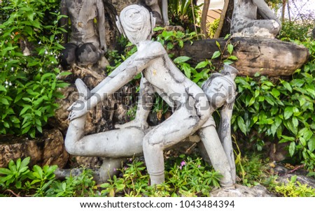 Old stone statue depicting a Nuad Boran (Thai massage) move at famous Wat Pho (Buddhist Temple) in Bangkok, Thailand Royalty-Free Stock Photo #1043484394