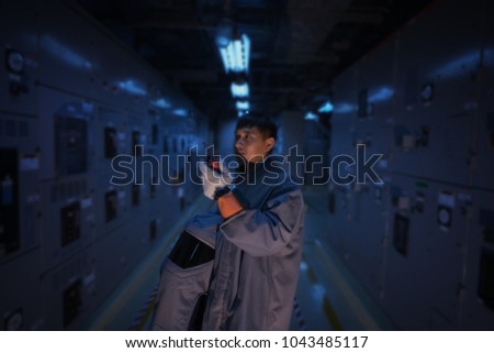 Engineer wear a arc flash protection suit for inspection electrical current 
 and checking status switch gear electrical energy distribution substation. Royalty-Free Stock Photo #1043485117
