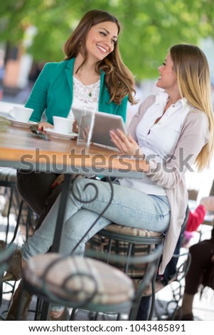 beautiful girls smiling and use digital tablet at the cafe
