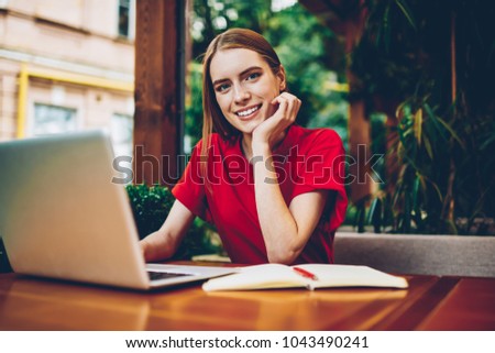 Half length portrait of attractive female owner of coffee shop working on online database of accounting reports using high speed internet connection and modern laptop computer for updating results