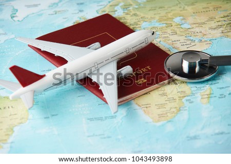 Medical travel concept with stethoscope passport document and airplane on world map background. Royalty-Free Stock Photo #1043493898