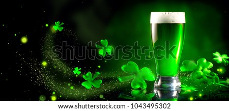 St. Patrick's Day Green Beer pint over dark green background, decorated with shamrock leaves. Patrick Day pub party, celebrating. Glass of Green beer close-up. Border art design, Wide format banner