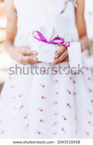 A little girl holds a gift box