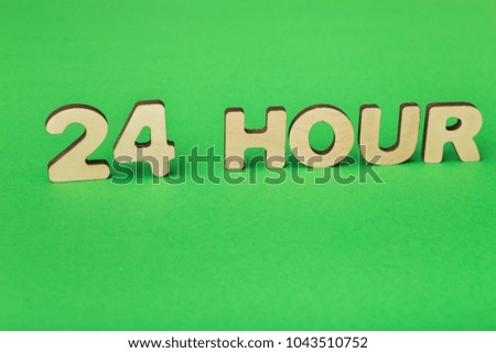 24 hour inscription made of wooden letters on green background. Day-and-nignt open, round-the-clock services and customers support, 24/7 access concept, copy space