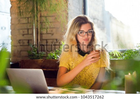 Young female student working on netbook, cute woman successful freelancer using laptop computer while sitting in coffee shop