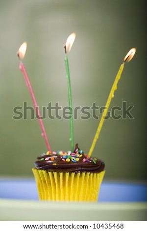 Birthday Cupcake on a Plate with Three Lighted Candles