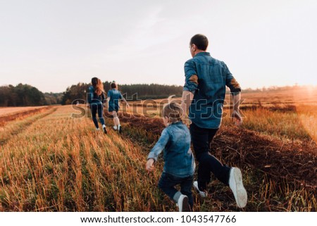 family running through field 
