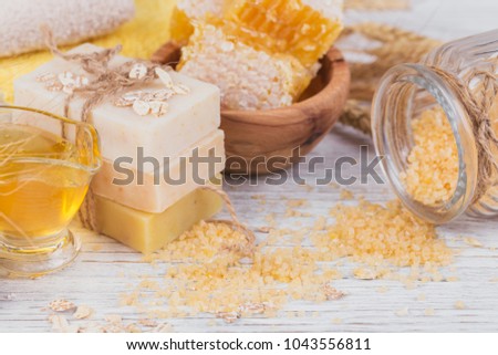 Honeycomb, sea salt, oats and handmade soap with honey on white rustic wooden background. Natural ingredients for homemade facial and body mask or scrub. Healthy skin care. SPA concept. Close up