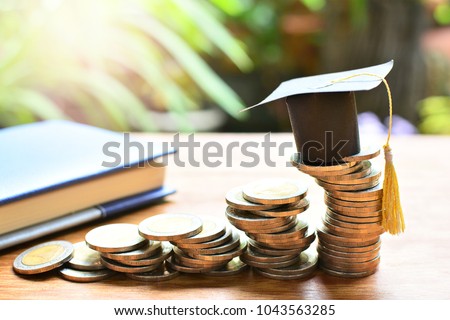 hat graduation model on coins saving for concept investment education and scholarships  Royalty-Free Stock Photo #1043563285