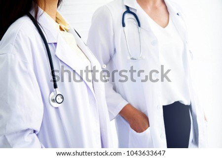 
Two professional senior female medical teams in white medical uniforms and stethoscope stand health care services : Healthcare and medical or health insurance concept