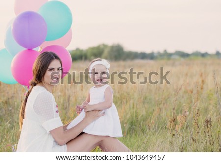happy mother and daughter with balloons outdoor