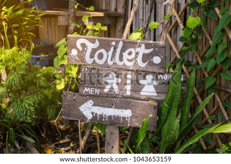 wooden sign for go to toilet with nature background. soft focus.