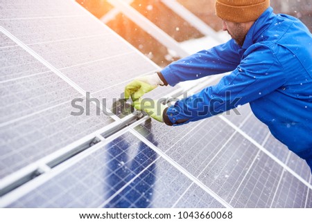Male electrician worker repairing solar panels outdoors alternative energy source environment friendly engineer power plant factory arrangement production equipment photovoltaic generation. Royalty-Free Stock Photo #1043660068