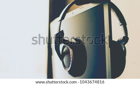 Headphones hanging on a laptop screen with soft lit background. 