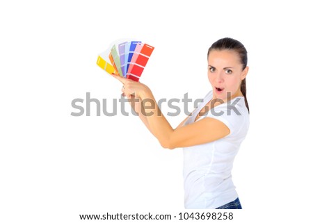 a girl with an amazed face chooses a color for repair in the room, isolated on white background