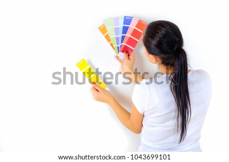 girl painter chooses the color of paint to repair the room