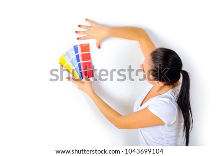 girl painter chooses the color of paint to repair the room