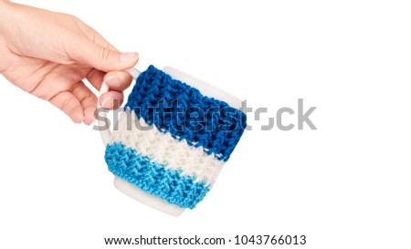 knitted tea cup in hand isolated on white background. copy space, template.