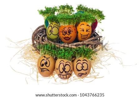 Handpainted Easter eggs in funny scared and surprised cartoonish faces with cress like hair. Handmade eggs in nest made of wicker hay, straw. The watercress stylized for the hairstyle of the character
