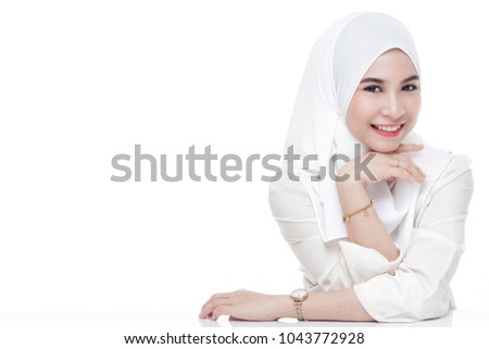 beautiful asian muslim woman wearing white shirt and white hijab posing on table isolated on white background.copy space