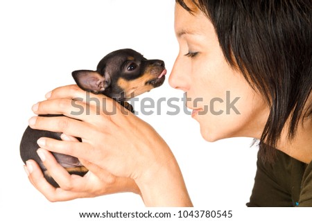 Woman is holding puppy in her hands