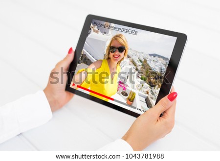Woman watching online video blogger on tablet computer