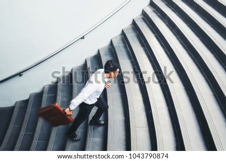 Businessman running fast upstairs Growth up Success concept Royalty-Free Stock Photo #1043790874