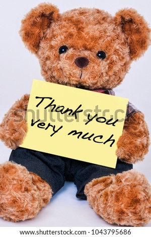 Cute teddy bear holding a yellow sign that says Thank you very much isolated on a white background