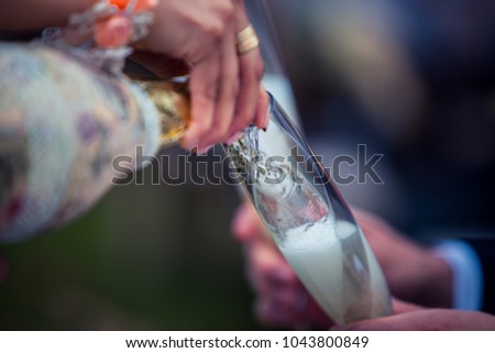 Pouring champagne into glass at hen-party, close up Royalty-Free Stock Photo #1043800849