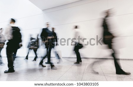 large crowd of blurred people walking in a futuristic corridor