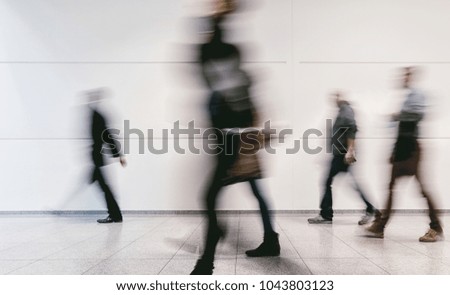 crowd of blurred people walking in a corridor