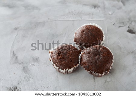 Tasty muffins arranged in pattern on light textured background, close-up, shallow depth of field, selective focus.