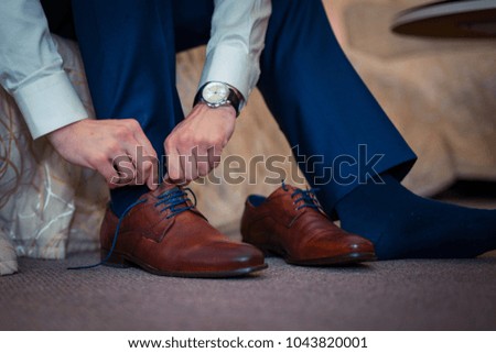 A businessman wears shoes. Royalty-Free Stock Photo #1043820001