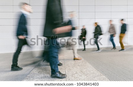 crowd of blurred people walking in a futuristic corridor