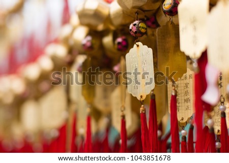Golden buddhist prosperity tag at Wong Tai Sin temple people wish and hang them on red ropes for praying in Hong Kong. Non-English in an image means wishing for good luck in coming year.