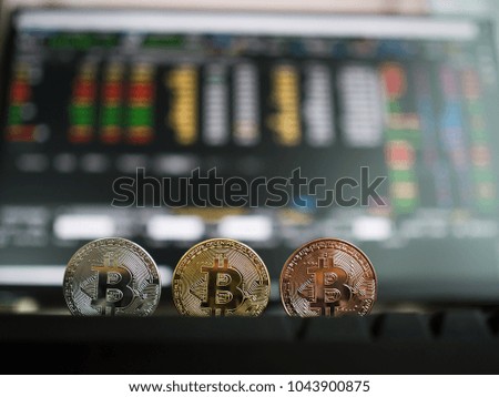 Golden silver and bronze bitcoin coins with Background of stock price table.