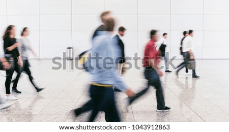 large crowd of blurred people in a modern hall