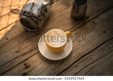 Top view of hot coffee latte art with coffee beans on wood table