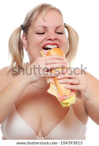 Funny picture of a hungry woman eating big sandwich with ham.