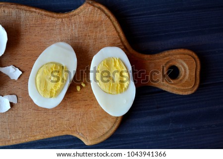 Sliced eggs, eggs shell on a wooden board. Macro food photography. Homemade food still life.