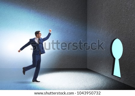 Businessman walking towards keyhole in challenge concept